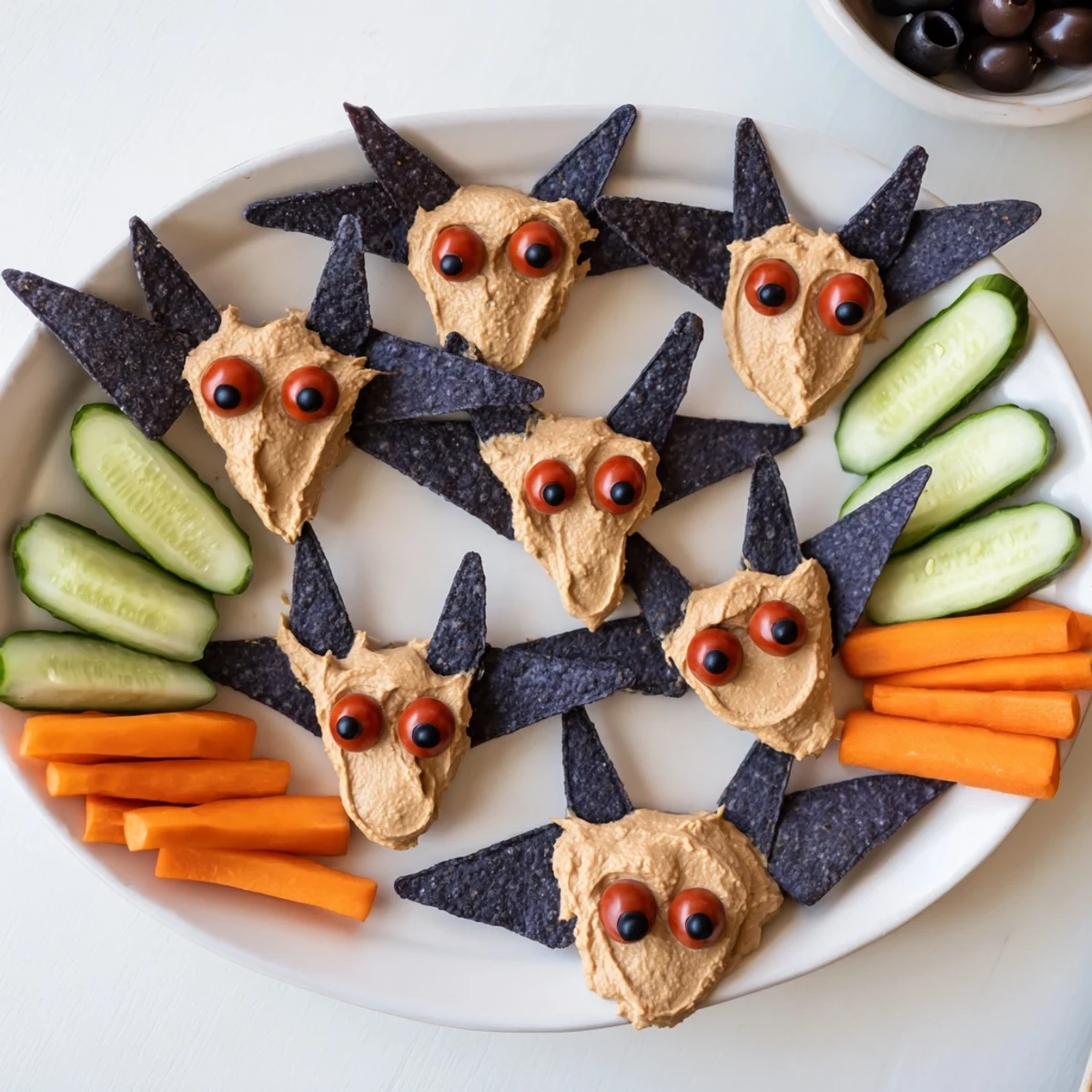 A spooky Spooky Bat Bean Dip Platter, perfect for Halloween, with creamy bean bats and colorful vegetables.