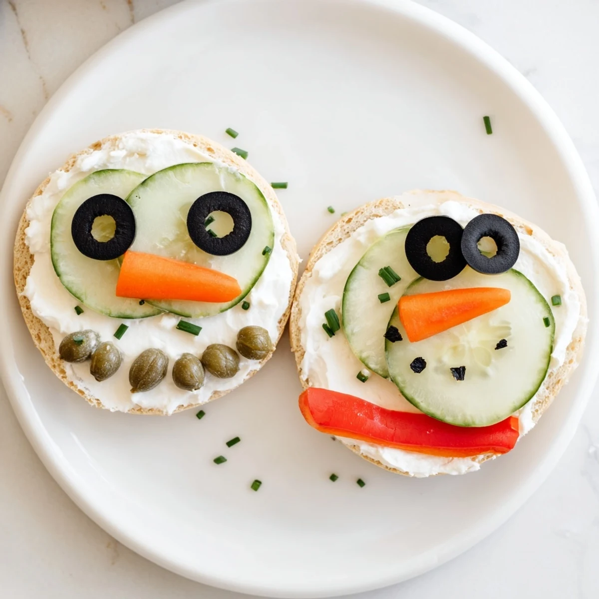 Snowman mini bagel sandwiches, festive lunch featuring adorable bagel snowmen with olive eyes and carrot noses.