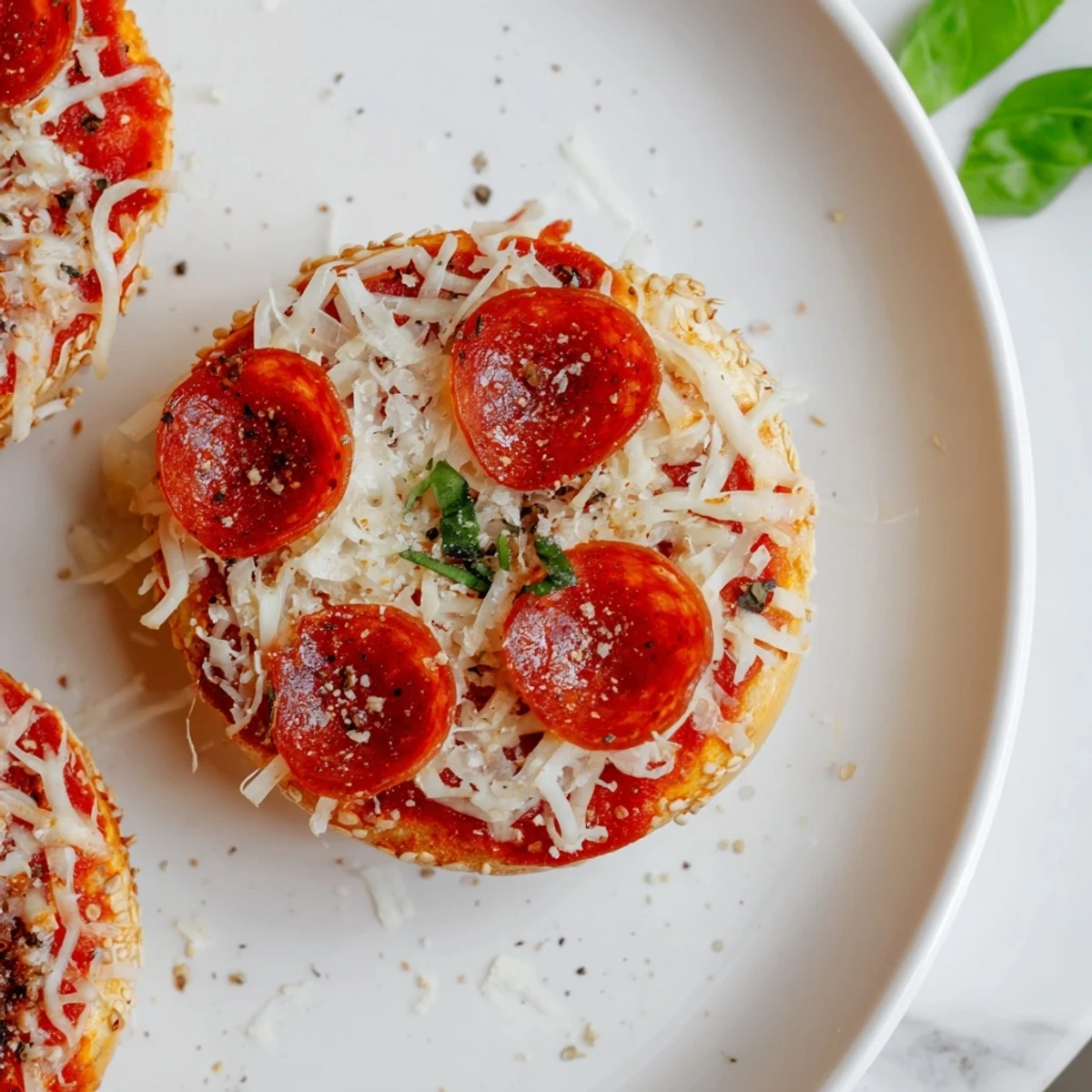 Warm, melty mozzarella covers these mini pepperoni pizza bagels, a savory snack ready in minutes.