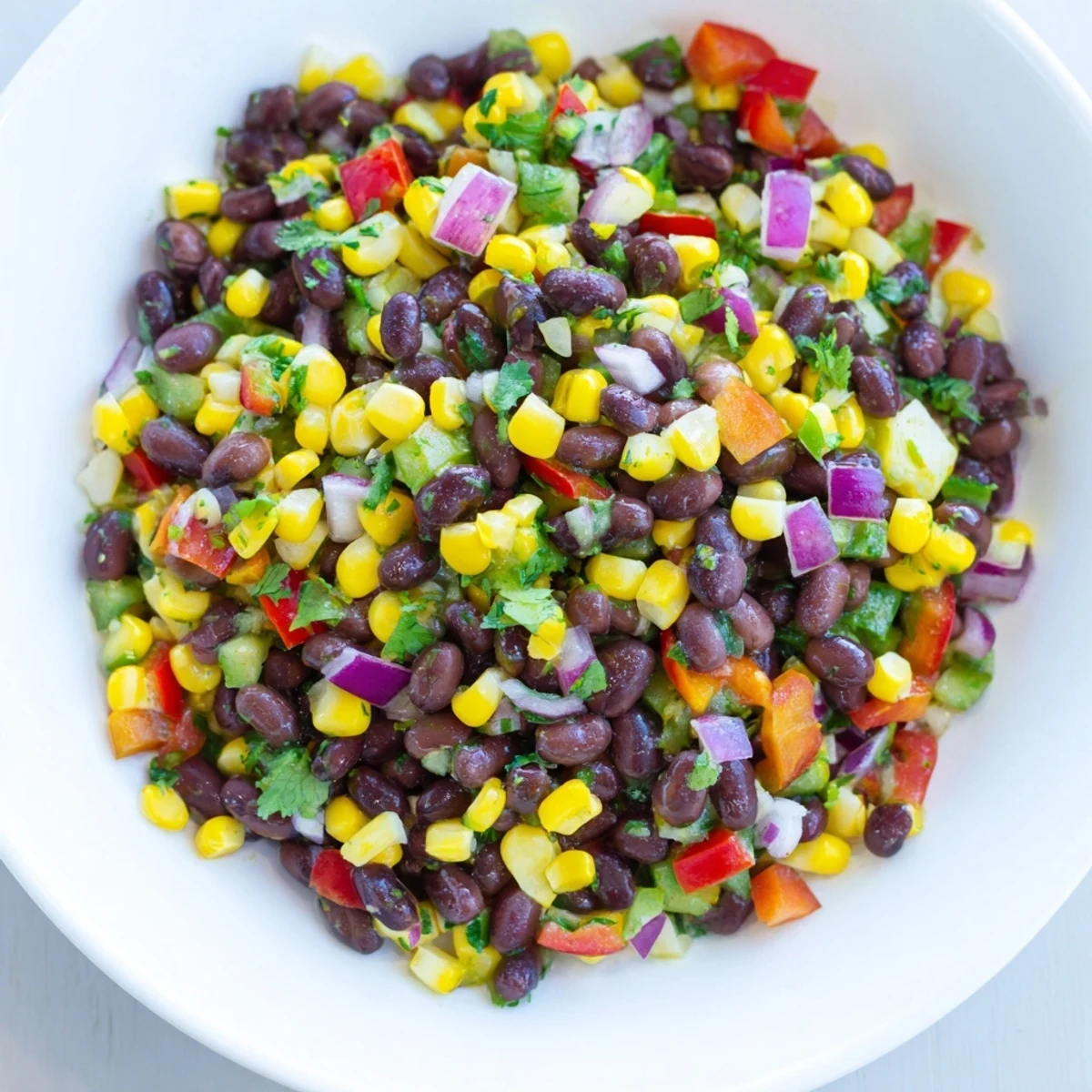 Fresh Cowboy Caviar Salad bursts with colorful vegetables and a zesty lime dressing, ready to eat.