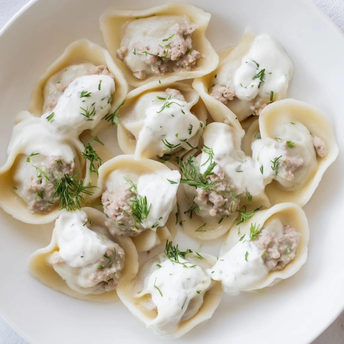 A plate of freshly cooked Russian Pelmeni, savory meat dumplings, perfect served hot.