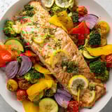 Golden, flaky salmon in a Salmon Sheet Pan Bake alongside vibrant roasted bell peppers, perfect for dinner.