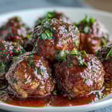 Aromatic slow cooker meatballs simmered to perfection, served warm with savory sauce and fresh parsley garnish.  