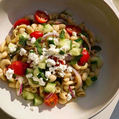 Vibrant Mediterranean white bean salad with creamy feta and colorful veggies, a refreshing lunch.
