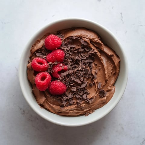 Silky smooth 5-Minute Chocolate Avocado Mousse, a rich, dark treat topped with fresh berries.