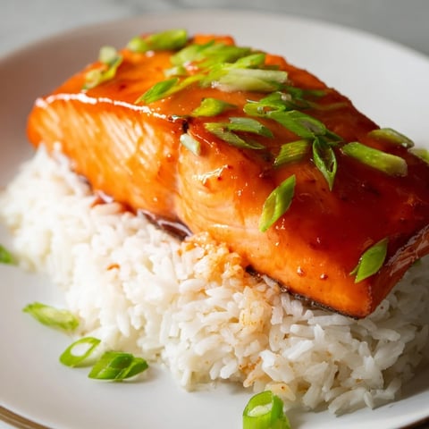 Sticky Orange Salmon displayed on a plate, salmon glistening with glaze beside fluffy rice.