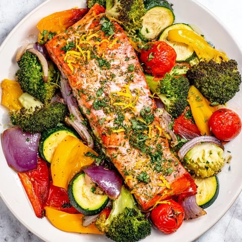 Close-up view of a flavorful Salmon Sheet Pan Bake featuring roasted salmon and colorful, tender vegetables.