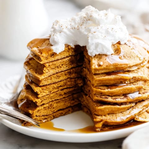 Warm, fluffy pumpkin spice pancakes, light and airy, cooked on a griddle ready to be enjoyed.