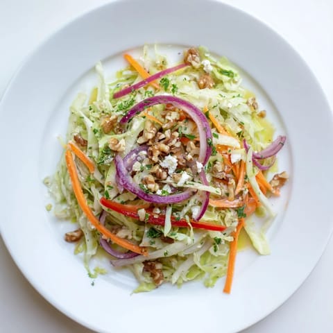 Freshly tossed Cooked and Loved Cabbage Salad with sautéed cabbage, julienned carrots, red onion, and red bell pepper glistening with a tangy dressing.
