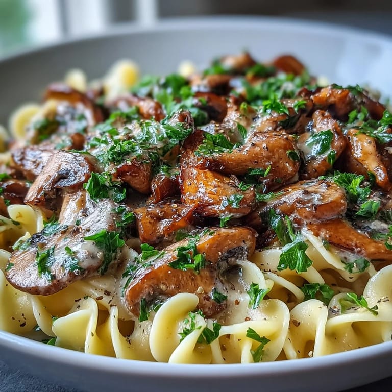 Close-up of Creamy Mushroom Stroganoff with silky sauce clinging to wide egg noodles.