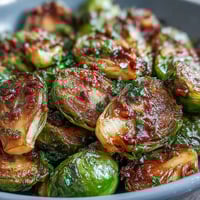 Roasted Brussels sprouts tossed with fresh herbs, lemon zest, and crunchy almonds for a vibrant, flavorful side dish.  